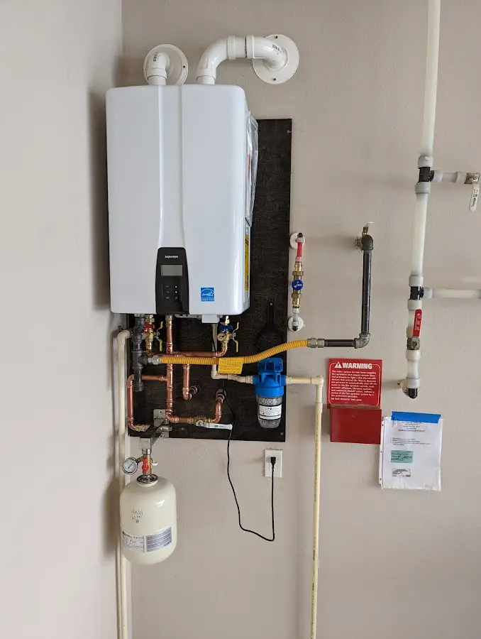 Professional plumber installing copper piping in a West Manchester home